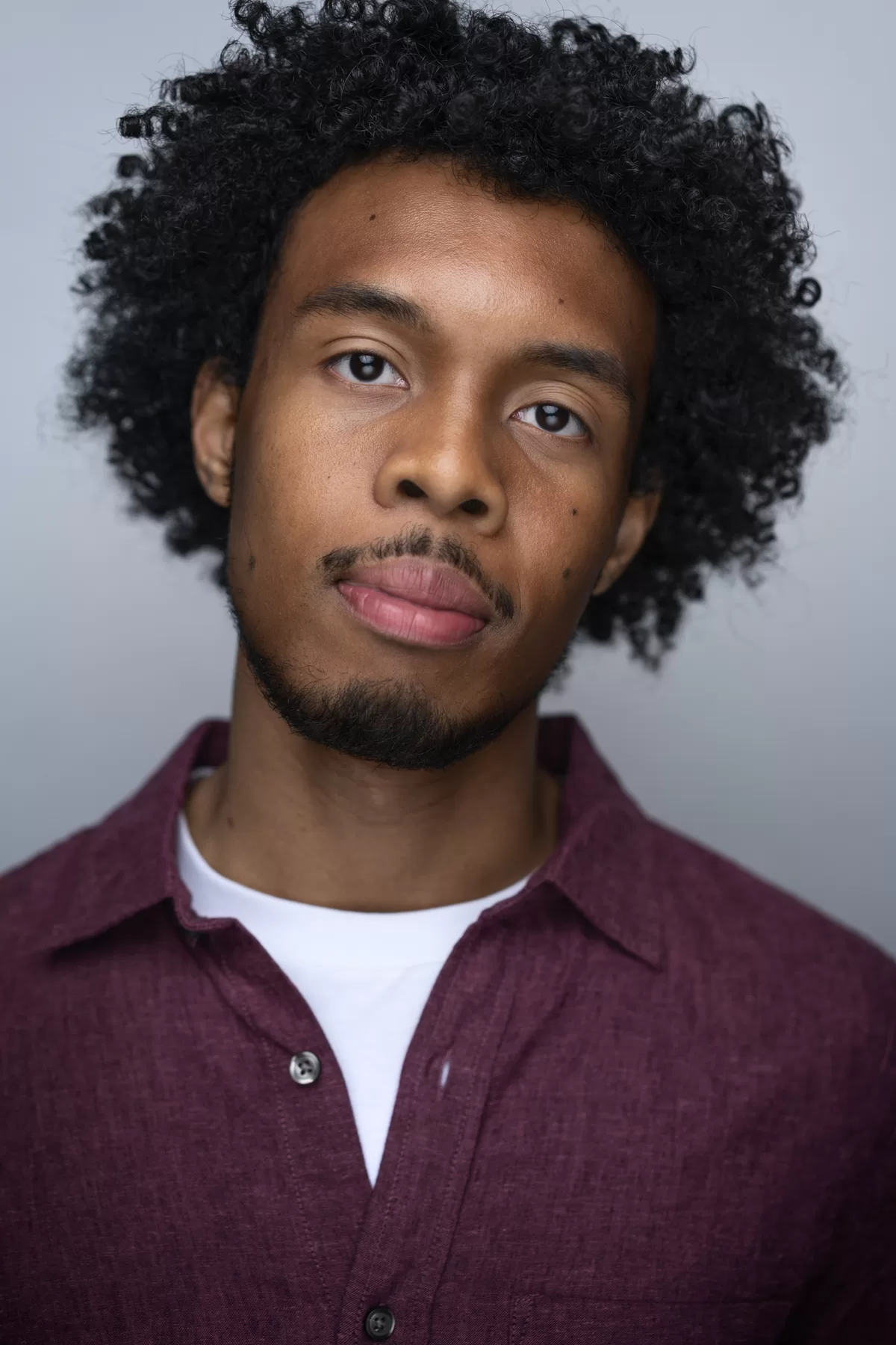 Studio actor headshot of Cayanne wearing a burgundy overshirt