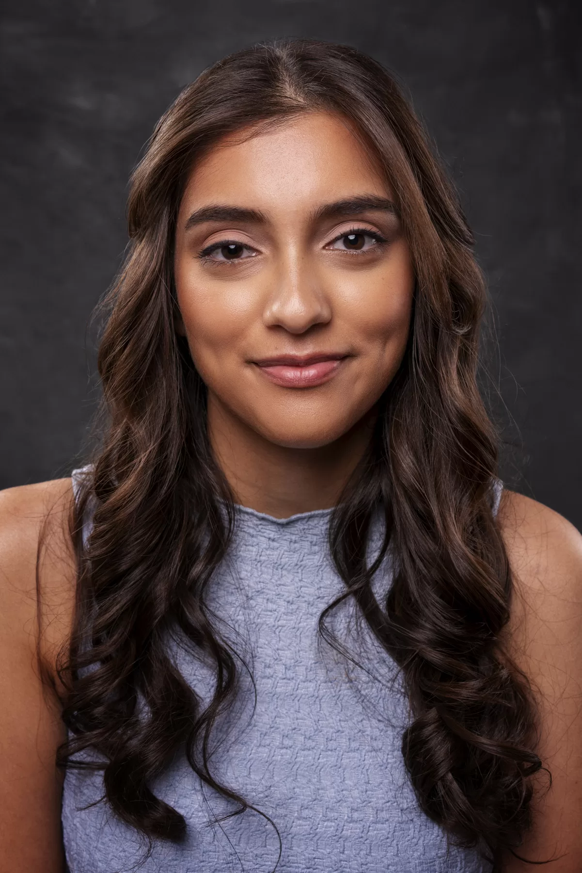 Commercial headshot of actor Maeggan Palliyaguru with long dark hair