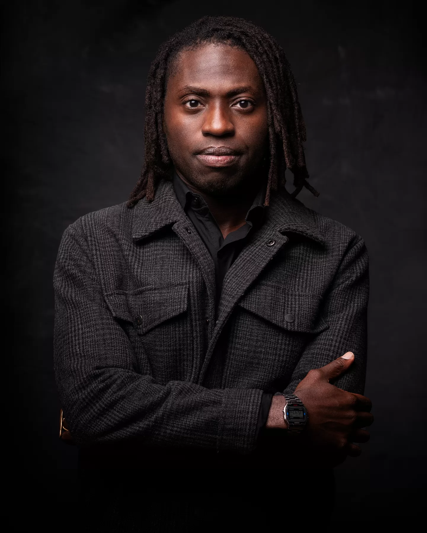 Dramatic studio actor headshot of a Black man in a dark jacket
