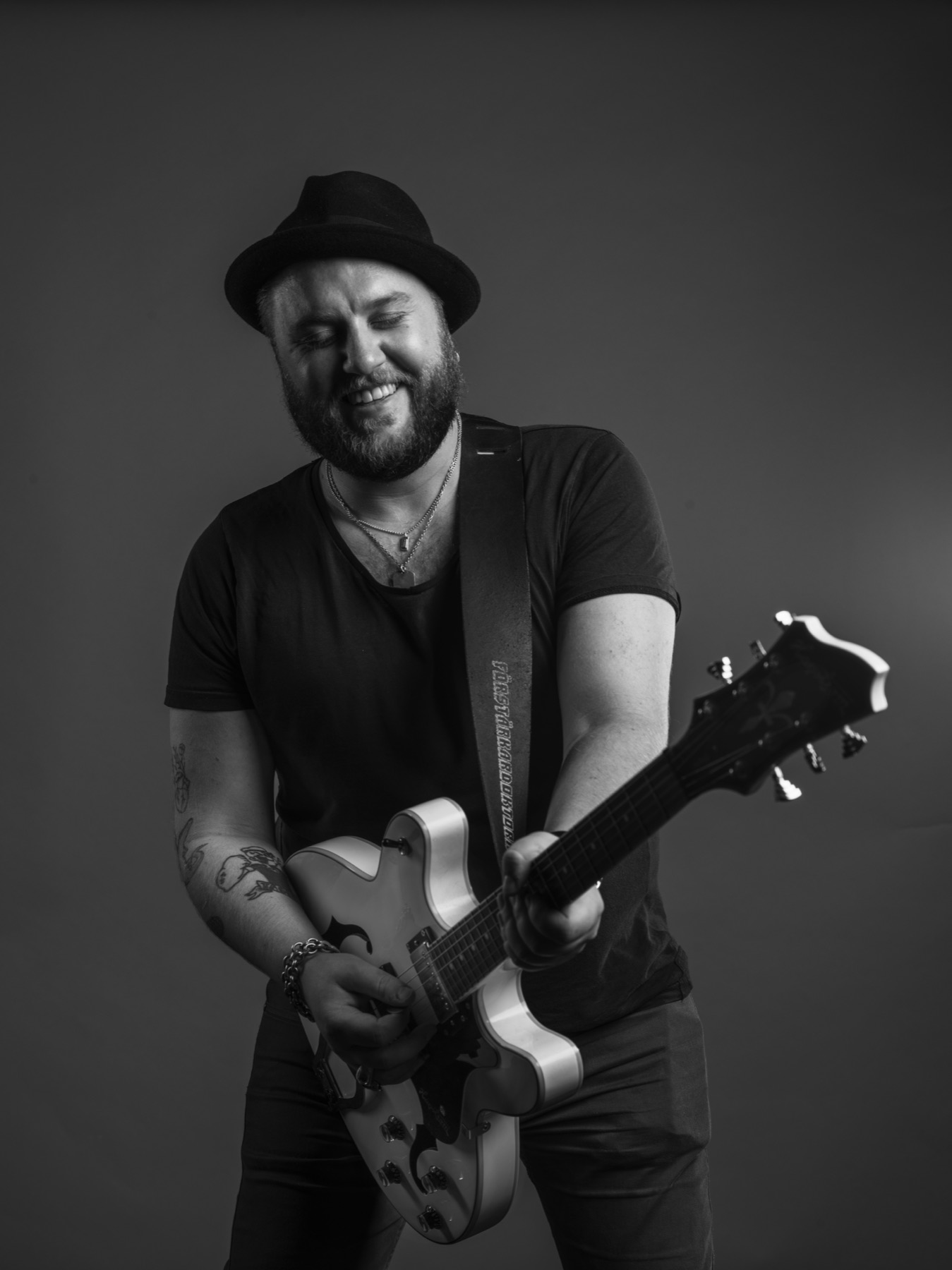 Black and white performance portrait of Mannerfors playing guitar