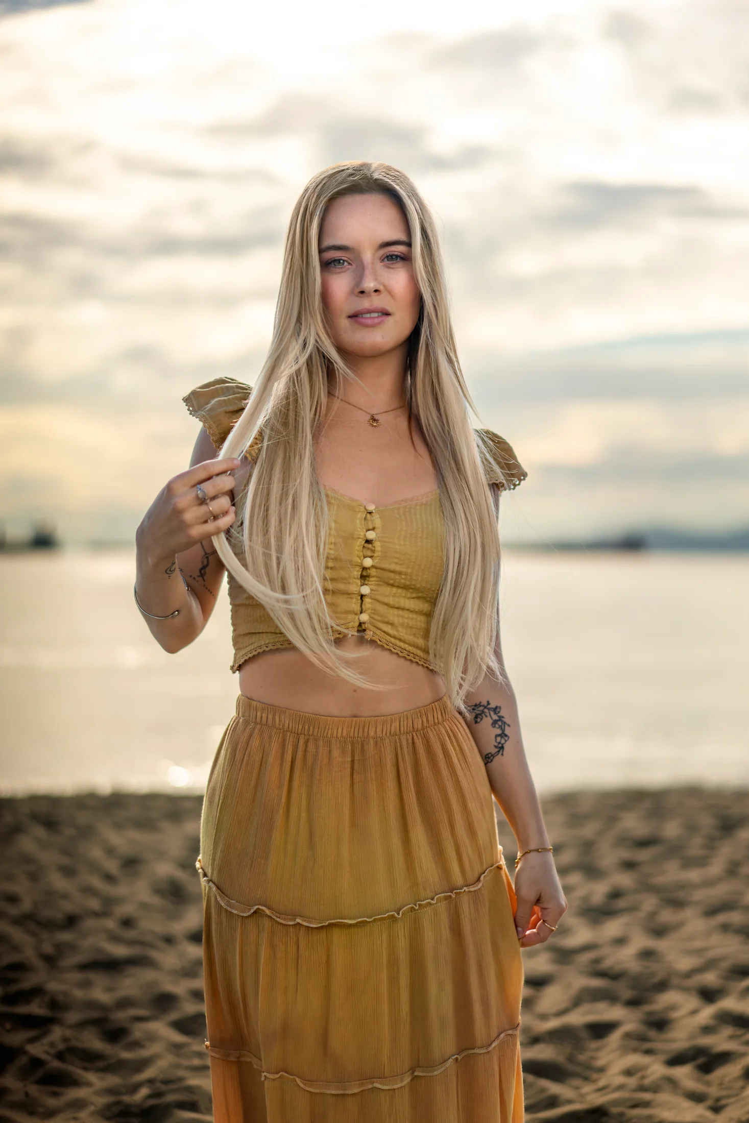 Actor Camille Felton standing on the beach in a golden outfit