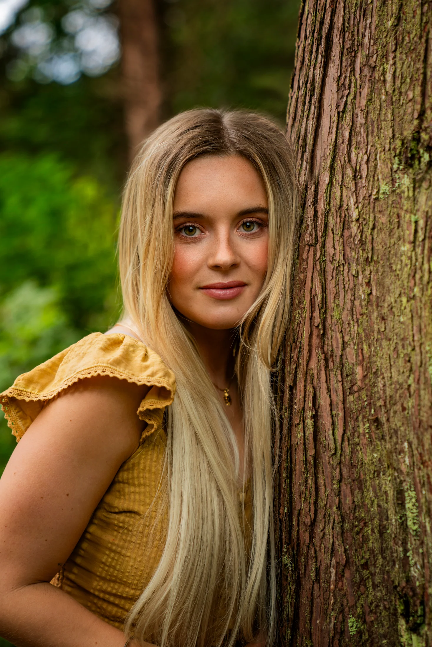 Camille Felton beside a tree in the forest