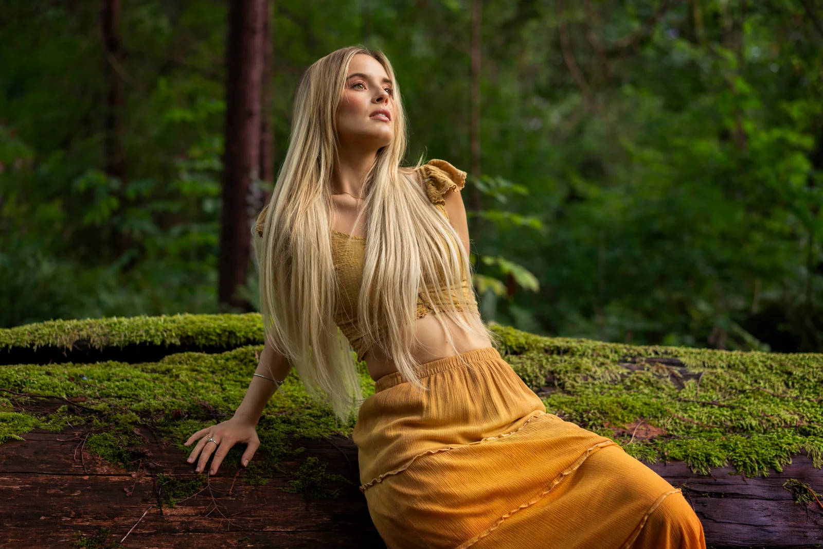 Camille Felton seated on a moss-covered log