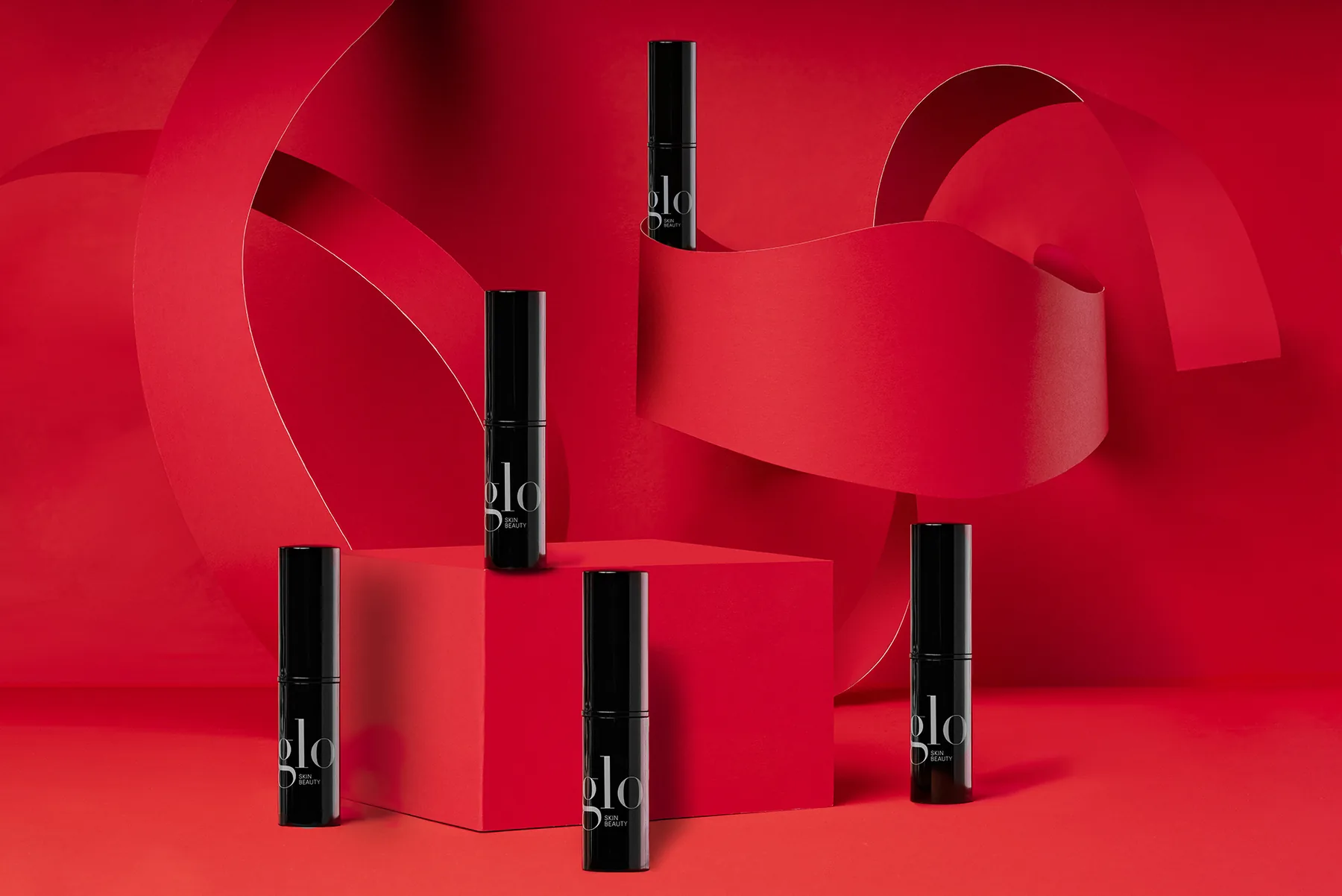 Cosmetic products arranged on a sculptural red commercial photography set