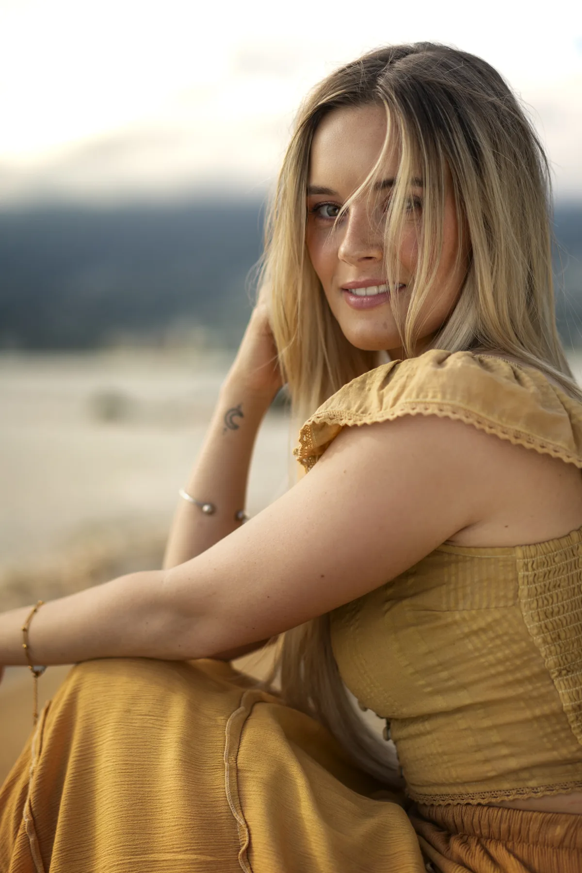 Environmental editorial portrait of a woman in gold on a Vancouver beach