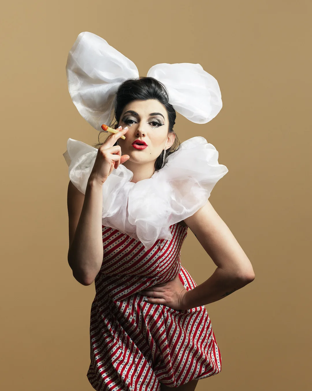 Fashion editorial portrait with theatrical costume and graphic white styling