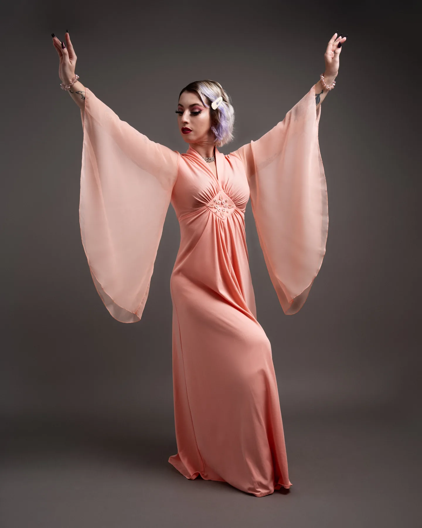 Full-length fashion portrait with a flowing pale pink gown