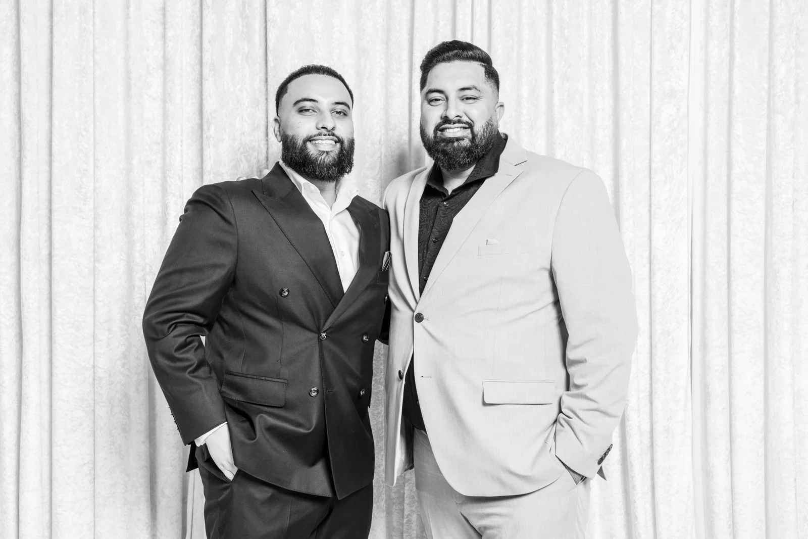 Two friends smiling together in formal jackets