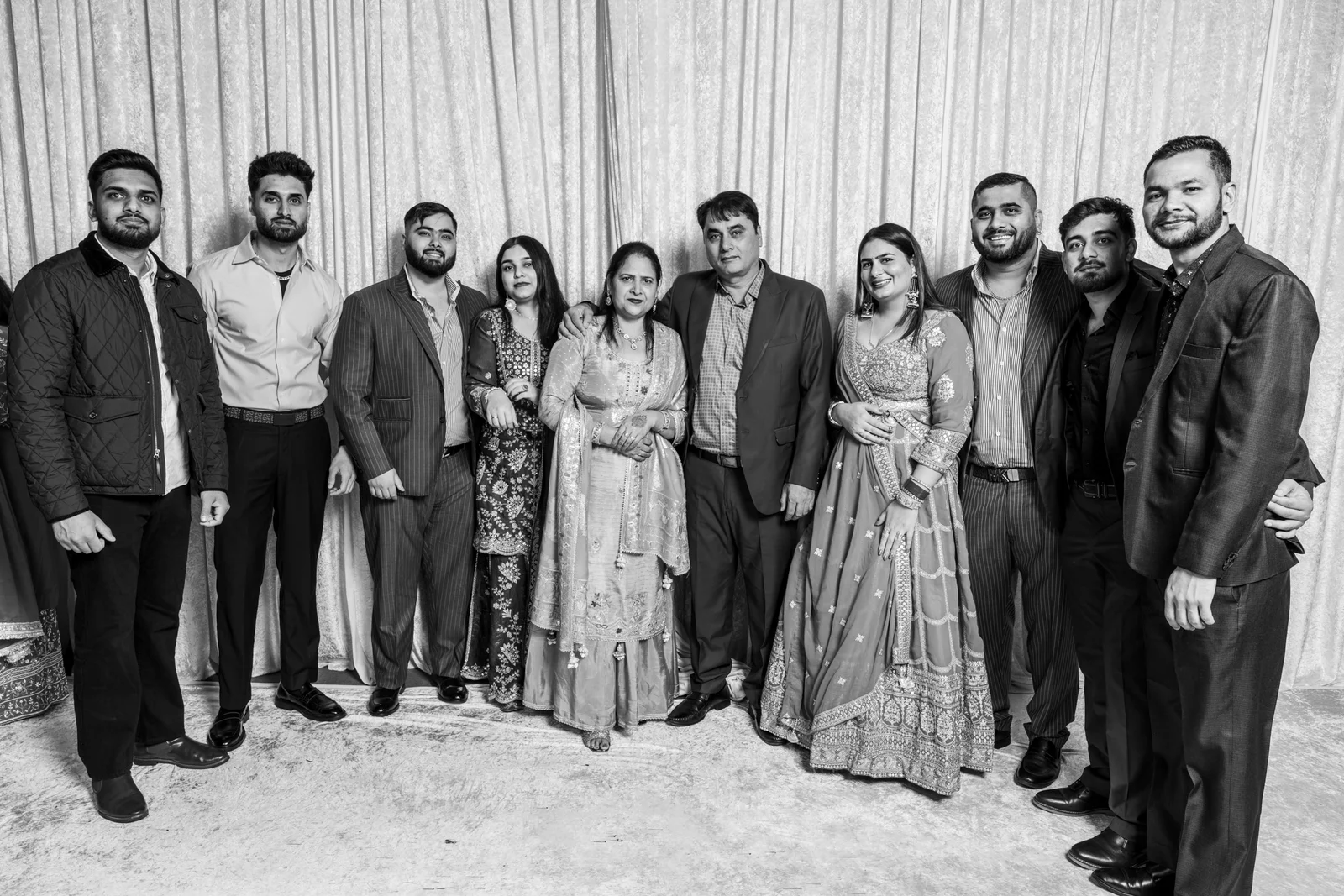 A large group of wedding guests gathered for a full-length portrait