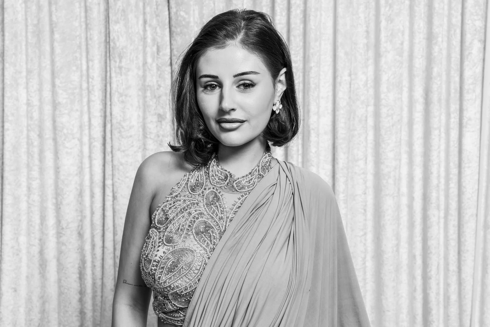 Close black-and-white portrait of a wedding guest in an embroidered sari