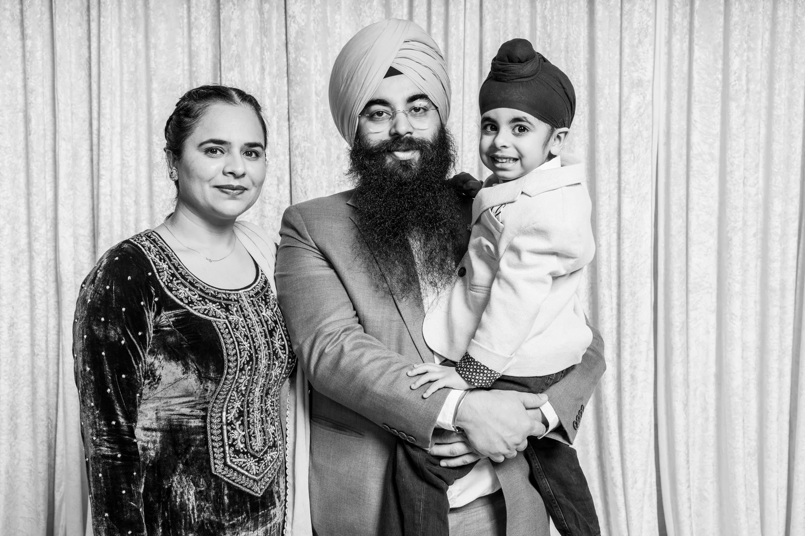 Parents holding their smiling child for a family portrait