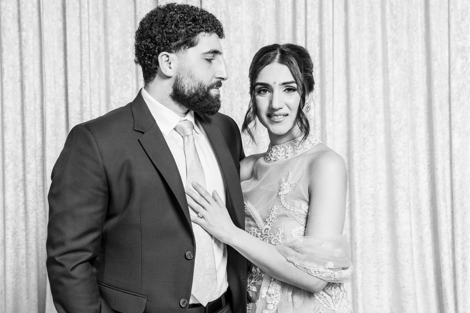 A couple sharing a relaxed moment in front of the portrait backdrop