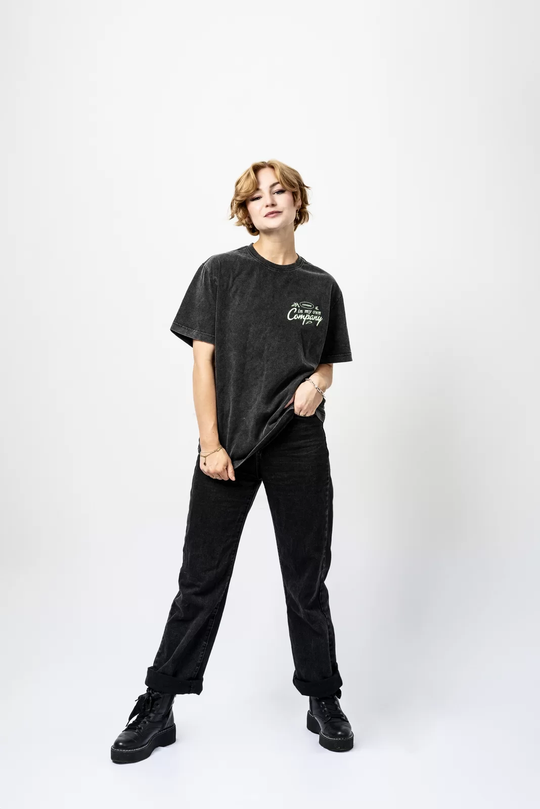 Full-length personal branding portrait of Kall Me Kris in a black graphic T-shirt