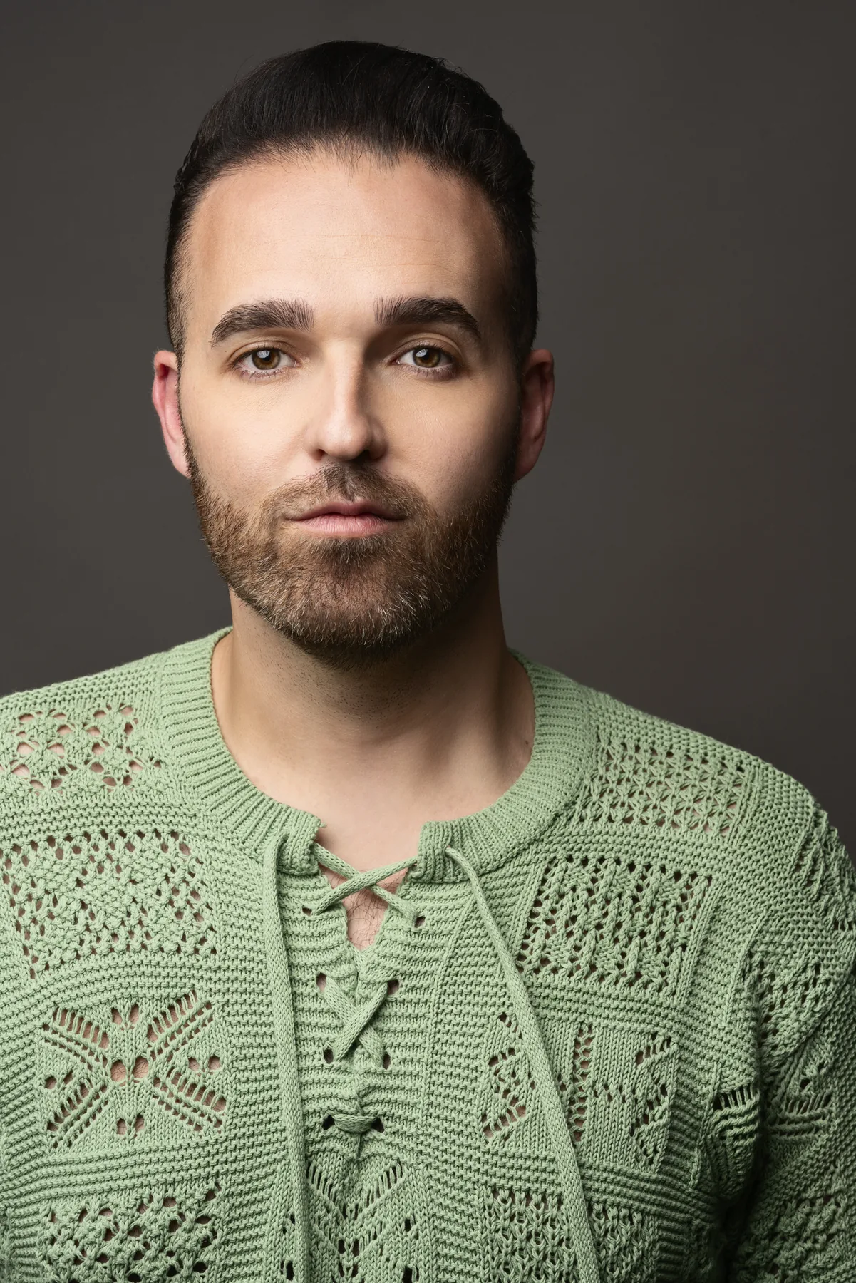 Creative professional portrait of a man wearing a textured green sweater