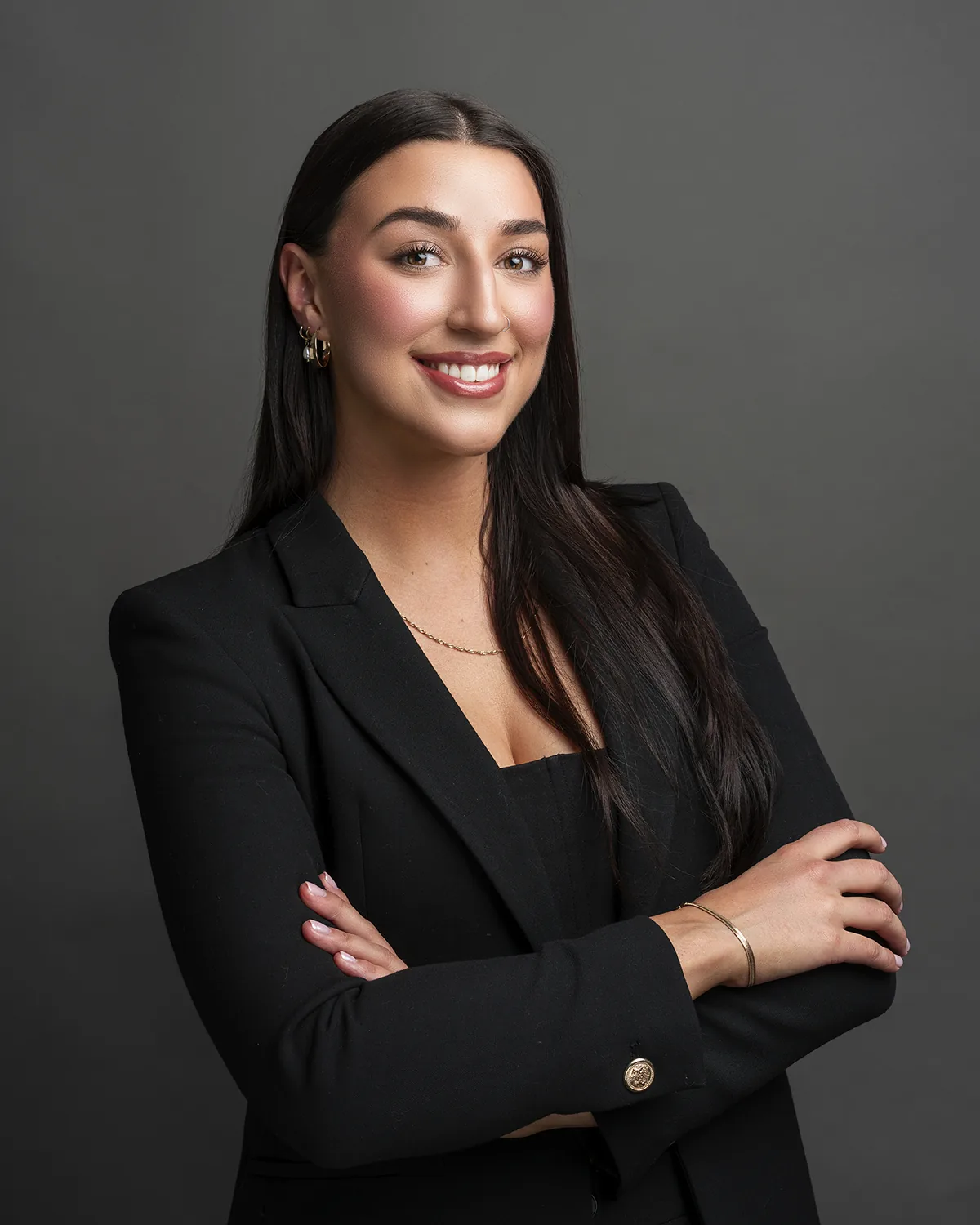 Studio business portrait of a woman in a black blazer with folded arms